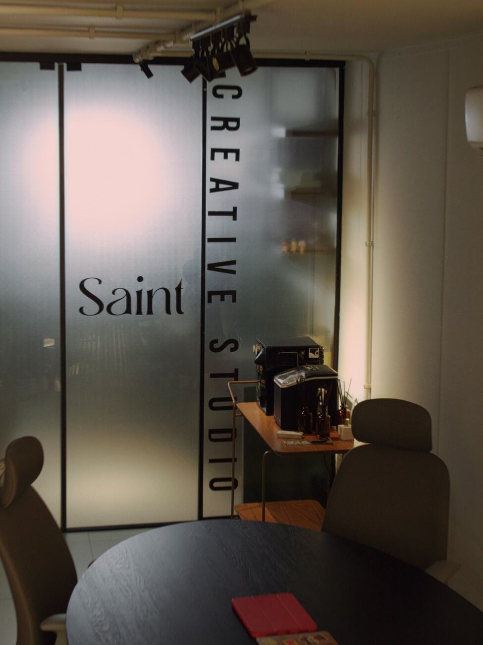 Porta de vidro com Saint Creative Studio e a sala de reunião ao fundo