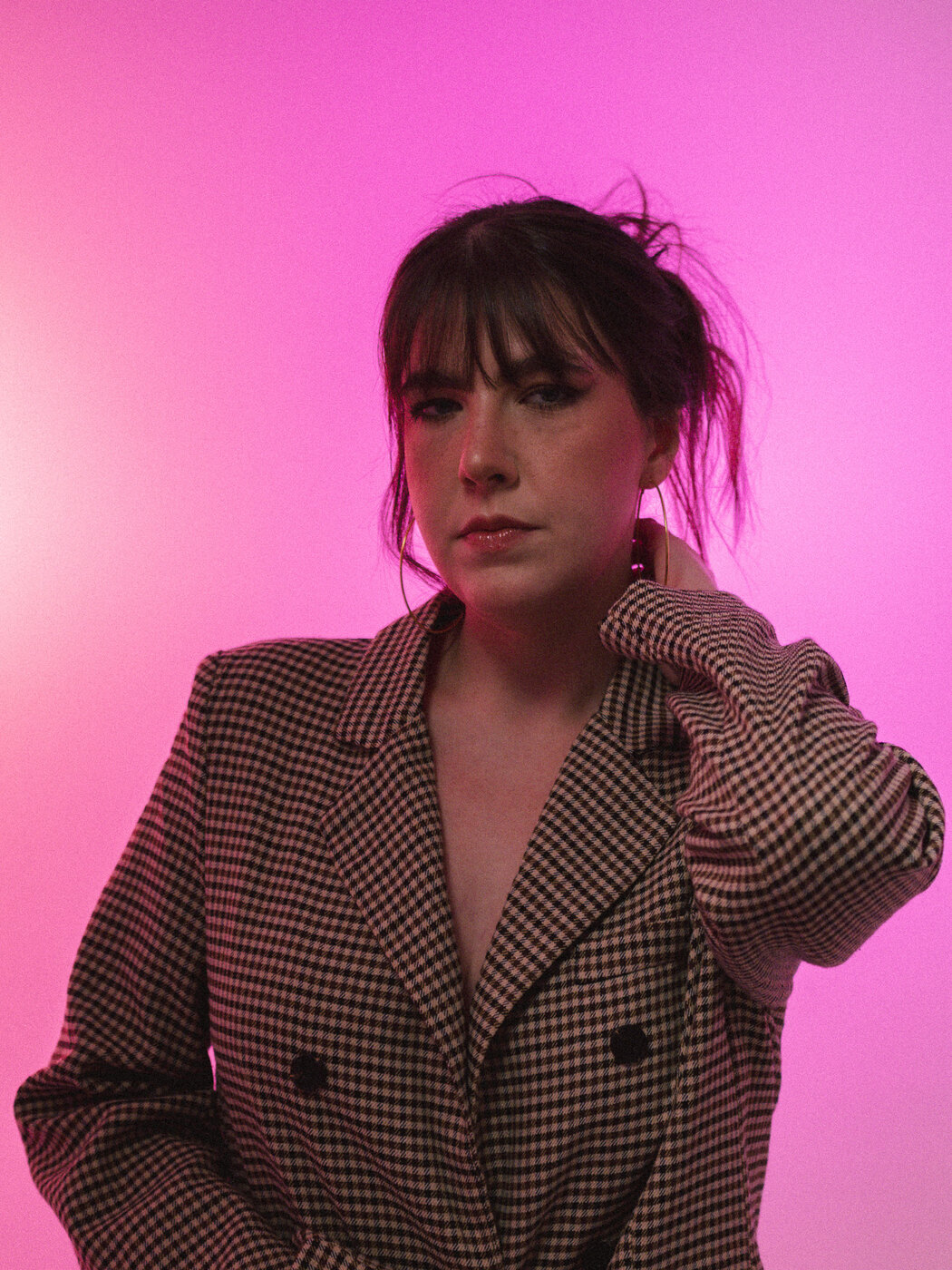 Retrato com blazer xadrez sobre fundo rosa