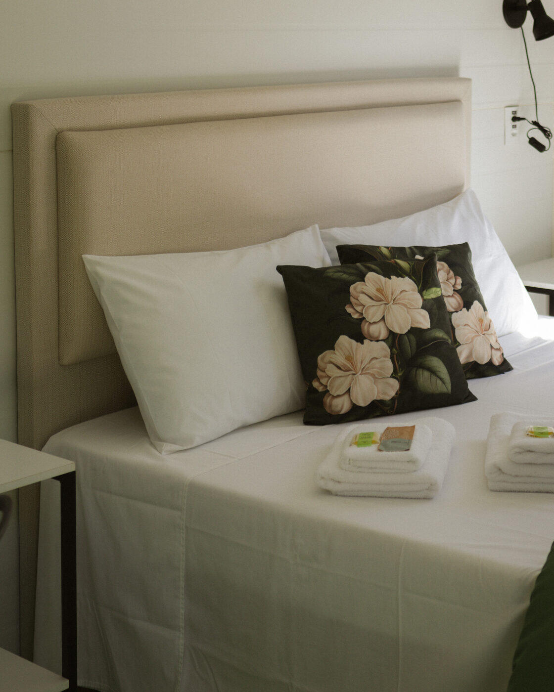 Cama arrumada com almofadas de flores