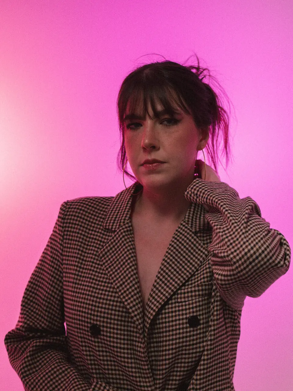 Retrato com blazer xadrez sobre fundo rosa